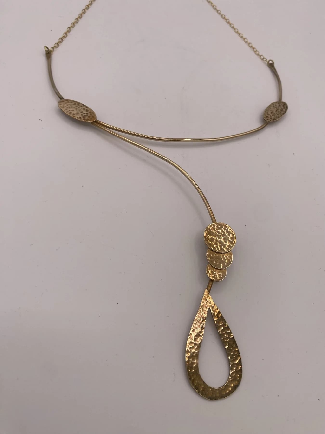 Close view of the textured loop pendant and chain.